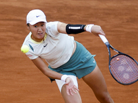 Xiyu Wang of China is in action against Iga Swiatek of Poland on Day Three during their second-round match at the Mutua Madrid Open at La Ca...
