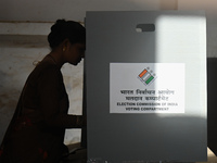 A woman is casting her vote in an Electronic Voting Machine (EVM) at a polling station during the second phase of the Indian General Electio...