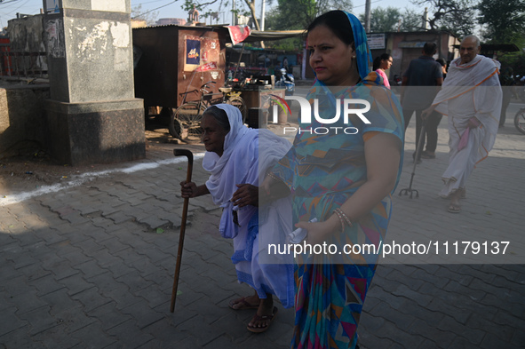 An elderly woman is arriving at a polling station to cast her vote during the second phase of the Indian General Elections in Vrindavan dist...