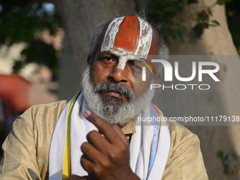 A Hindu holy man is showing his inked finger after casting his vote at a polling station during the second phase of the Indian General Elect...