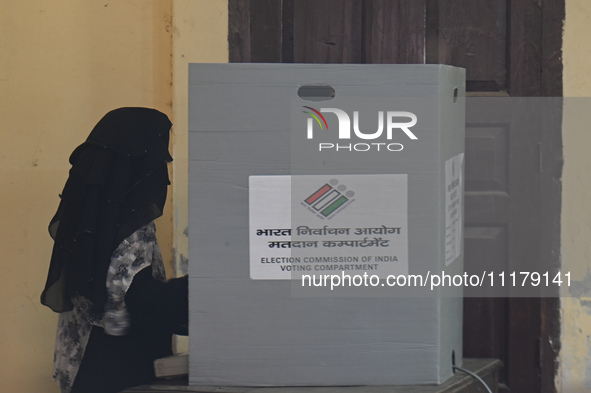 A woman is casting her vote in an Electronic Voting Machine (EVM) at a polling station during the second phase of the Indian General Electio...