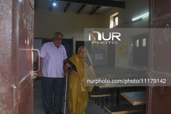An elderly woman, aged 102, is walking out of the polling station after casting her vote during the second phase of the Indian General Elect...