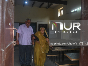 An elderly woman, aged 102, is walking out of the polling station after casting her vote during the second phase of the Indian General Elect...