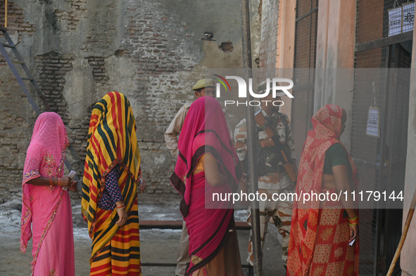 Women are standing in a queue at a polling station to vote during the second phase of the Indian General Elections in Vrindavan district, Ut...