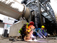 Construction workers are welding pipes for an incinerator at the incineration workshop of the Zhangye Hazardous Waste (Solid Waste) Disposal...