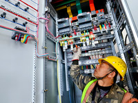 A construction worker is installing electrical equipment at the incineration workshop of the Zhangye Hazardous Waste (solid waste) Disposal...