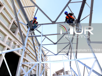 Construction workers are linking a steel tower at the construction site of the Zhangye Waste Disposal and Resource Utilization Center in Zha...
