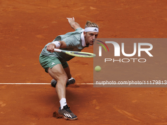 Alejandro Davidovich is returning a shot against Juncheng Shang during their match on Day 5 of the Mutua Madrid Open at Caja Magica Stadium...