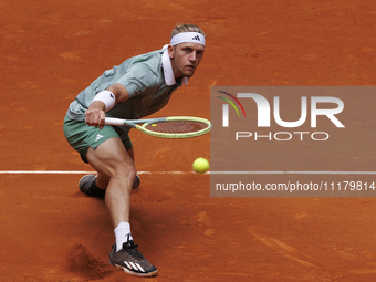 Alejandro Davidovich is returning a shot against Juncheng Shang during their match on Day 5 of the Mutua Madrid Open at Caja Magica Stadium...