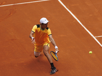 Juncheng Shang is returning a shot against Alejandro Davidovich during their match on Day 5 of the Mutua Madrid Open at Caja Magica Stadium...