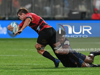Ethan Blackadder (L) of the Crusaders is being tackled by the defense of the Rebels during the round ten Super Rugby match between the Crusa...
