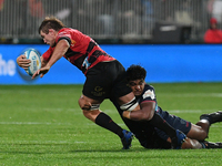 Ethan Blackadder (L) of the Crusaders is being tackled by the defense of the Rebels during the round ten Super Rugby match between the Crusa...