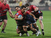 Noah Hotham (C) of the Crusaders is being tackled by the defense of the Rebels during the round ten Super Rugby match between the Crusaders...