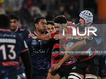 Quinten Strange (2R) of the Crusaders is being tackled by the defense of the Rebels during the round ten Super Rugby match between the Crusa...