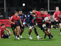 Quinten Strange (3R) of the Crusaders is being tackled by the defense of the Rebels during the round ten Super Rugby match between the Crusa...