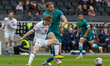 Sutton United's captain Harry Smith is being challenged by Milton Keynes Dons' Lewis Bate...