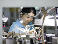 A worker is producing electronic products at a workshop in Nanchong, Sichuan Province, China, on April 29, 2024. (