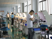 A worker is producing electronic products at a workshop in Nanchong, Sichuan Province, China, on April 29, 2024. (