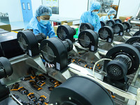 Workers are inspecting the air-dried outer packaging of black garlic and ginger extract on the automated production line of bio-tech supercr...