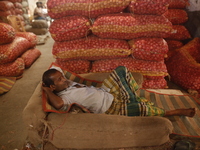 A vendor is sleeping on a hot summer day at a market in Dhaka, Bangladesh, on May 2, 2024. (