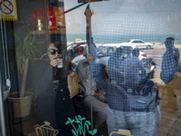 An Iranian woman is sitting at a cafe near a coastal street in Bushehr, Iran's first nuclear seaport city, located in Bushehr province on th...