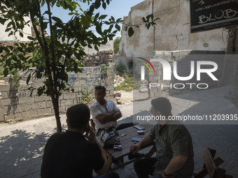 Iranian men are sitting together at an outdoor cafe in Bushehr, Iran, on April 28, 2024. This city is notable for being Iran's first nuclear...