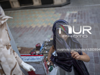 A young girl is standing at a bazaar and looking on in Bushehr, Iran, on April 28, 2024. This city is notable for being Iran's first nuclear...