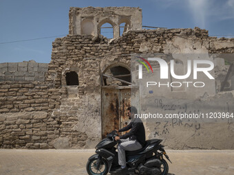 An Iranian motorcyclist is riding past an old building near a bazaar in Bushehr, Iran, on April 28, 2024. Bushehr is Iran's first nuclear se...