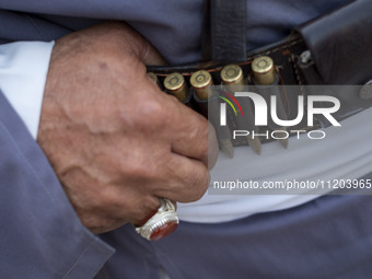 An elderly Iranian man is standing in a traditional military uniform with bullets in front of a governmental building in Bushehr, Iran, on A...