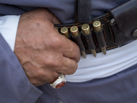 An elderly Iranian man is standing in a traditional military uniform with bullets in front of a governmental building in Bushehr, Iran, on A...