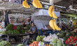 An Iranian man is riding a bicycle past fruit and vegetable shops at a bazaar in Bushehr,...