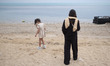 A young Iranian woman and a young girl are walking along a beach in Bushehr, Iran, on Apri...