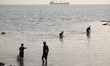Young Iranian boys are catching fish with colanders near the Bushehr nuclear power plant o...
