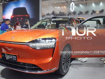 Visitors are looking at an AITO M9 electric car at the 2024 Beijing International Automotive Exhibition in Beijing, China, on May 3, 2024. (