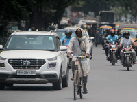 Commuters are taking precautions to beat the heat wave as they move through the market on a hot afternoon in Bhubaneswar, the capital city o...