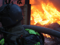 A firefighter is putting out a fire in a house following a Russian missile strike in Kharkiv, Ukraine, on May 4, 2024. (