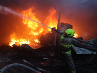 A firefighter is putting out a fire in a house following a Russian missile strike in Kharkiv, Ukraine, on May 4, 2024. (