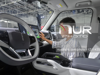 A child is experiencing an iCAR car at the 21st Anhui International Automobile Exhibition in Hefei, Anhui Province, China, on May 3, 2024. (