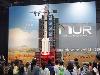 Visitors are watching a demonstration of a Long March 2F rocket launch simulation at the China Science and Technology Museum in Beijing, Chi...