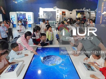 Visitors are participating in an interactive experience of ''Satellite Designers'' at the China Science and Technology Museum in Beijing, Ch...