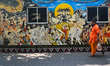 A priest is passing next to a mural of the Hindu lord Shiva on a hot summer day in Kolkata...