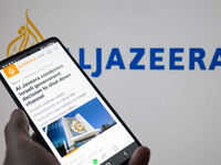 The Al Jazeera website is being displayed on a smartphone with Al Jazeera visible in the background in this photo illustration, taken in Bru...