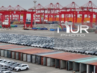 New energy vehicles are being loaded into containers for export at Taicang Port and Taicang International Terminal in Suzhou, Jiangsu Provin...