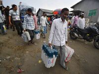 Indian election officials are carrying Electronic Voting Machines (EVM) and other election materials along the bank of the Brahmaputra River...