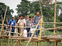 Election officials are carrying EVMs and other materials to their respective polling booths over a bamboo bridge on the eve of the third pha...