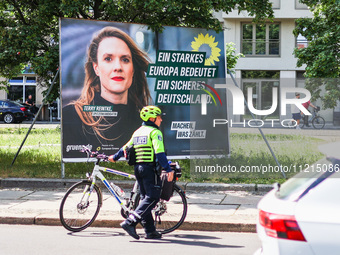 A police officer is standing next to an election campaign poster of the German Green Party candidate Terry Reintke, which reads: ''A strong...