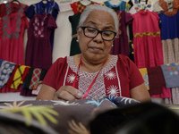A woman is sewing fabrics at the Apapacho Fair in Mexico City, at the National Museum of Popular Cultures, on the eve of Mother's Day, where...