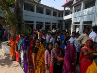 People are waiting in a queue to cast their votes at a polling station during the third phase of the Indian General Elections in Hathras dis...