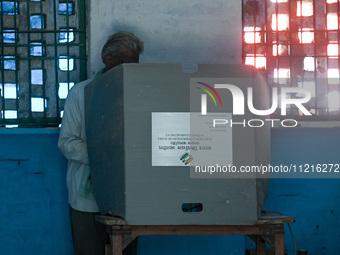 A man is casting his vote in the Electronic Voting Machine (EVM) at a polling station during the third phase of the Indian General Elections...
