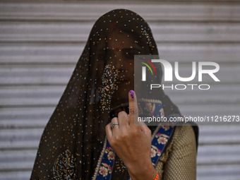 A woman is showing her inked finger after casting her vote at a polling station during the third phase of the Indian General Elections in Ha...